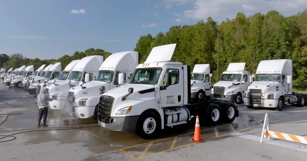 Sharp Transit employee power washes the clean fleet of late model CDL trucks